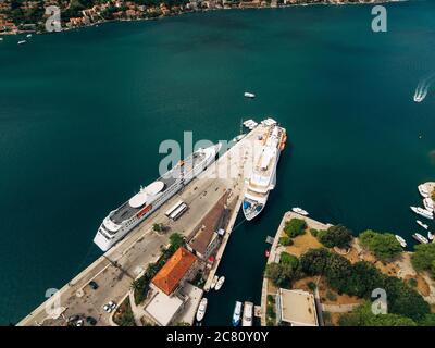 Aerial shot from the drone - two liners moored on the pier near the old town of Kotor, in the Gulf, Montenegro. Top view. Stock Photo