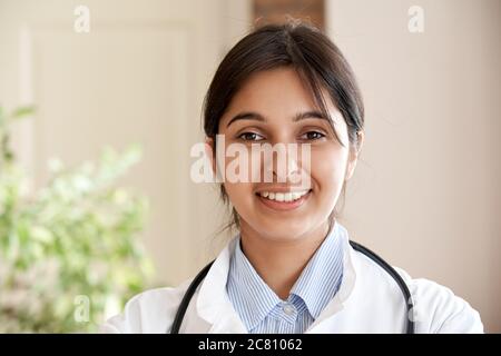 Smiling indian female doctor wear white coat look at camera, headshot portrait. Stock Photo