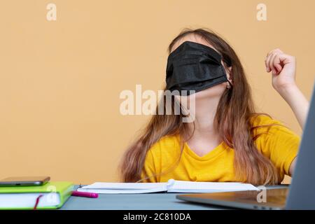 COVID-19 Pandemic Coronavirus Mask Woman Home Working Isolation Laptop Computer Auto Quarantine. Girl wearing face mask smart home working on a home Stock Photo