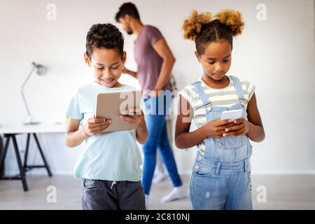 Happy children havig fun and using technology devices Stock Photo