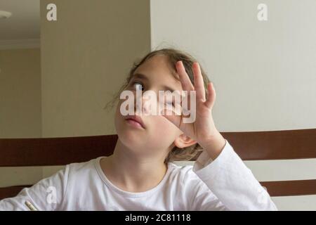 Elementary student makes her homework. She makes her own homework alone at home because of the schools  are on closed because of the corona pandemi Stock Photo