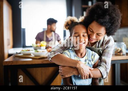 Happy family in the kitchen having fun and cooking together. Healthy food at home. Stock Photo