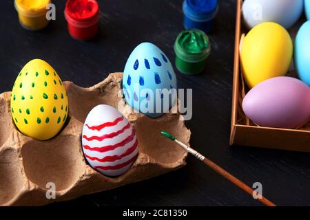 Coloring Easter eggs in different colors and patterns. Stock Photo
