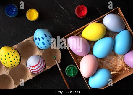 Coloring Easter eggs in different colors and patterns. Stock Photo