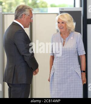 The Duchess of Cornwall is greeted by Chairman of Board of Trustees Mark Carne during a visit to Cornwall Air Ambulance Trust's base in Newquay to launch the new 'Duchess of Cornwall' helicopter, while on a three day visit to Cornwall with the The Prince of Wales. Stock Photo