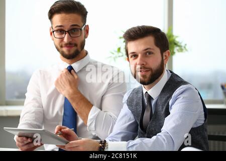 Two cheerful managers working in office with touchpad Stock Photo