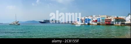 Little Venice houses in Chora Mykonos town with yacht and cruise ship. Mykonos island, Greecer Stock Photo