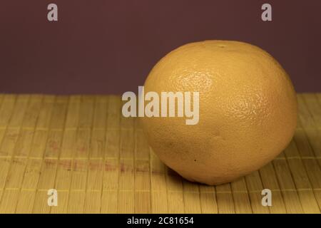 One grapefruit on a bamboo background Stock Photo