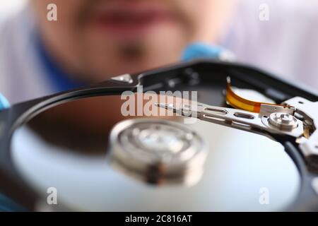 Man looking at compact disk reader out of computer Stock Photo