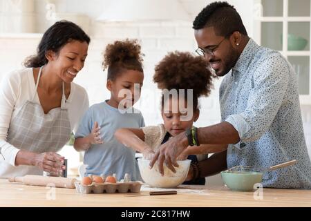 Happy african american family with kids baking at home Stock Photo