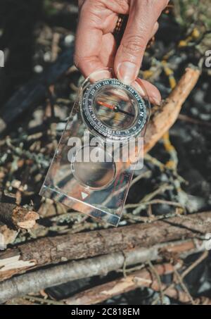 Woman uses a magnifying glass to burn a bonfire. Stock Photo