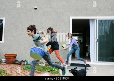 Siblings dash outside with their empty easter baskets to collect eggs Stock Photo