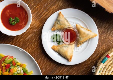High angle shot of plates of traditional Ethiopian food with vegetables on a wooden surface Stock Photo