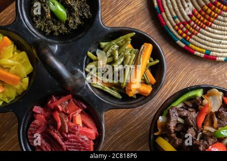 High angle shot of delicious traditional Ethiopian food with vegetables on a wooden surface Stock Photo