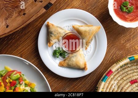 High angle shot of plates of traditional Ethiopian food with vegetables on a wooden surface Stock Photo