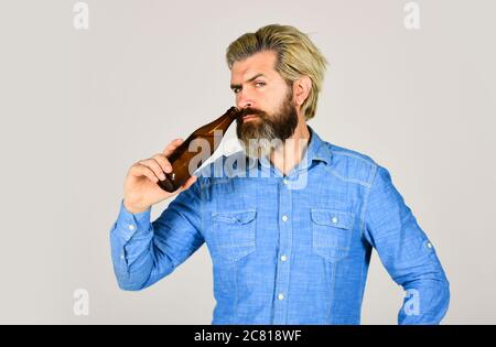male holding bottle of beer. hipster rest in pub. Sports lover cheer up. mature man holding glass bottle of beer. drunk hipster male craft bottled beer. happy man hold full glass bottle in hand. Stock Photo