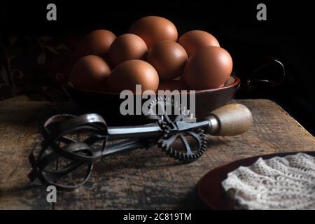 fram house fresh eggs on a wooden table with iron whisk Stock Photo