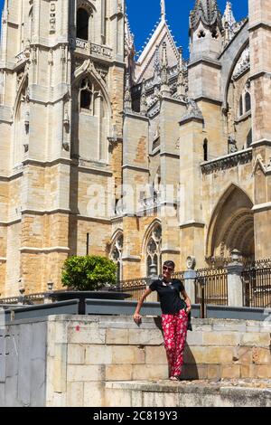 a woman smiling in front of the cathedral of Leon in Spain Stock Photo