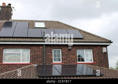 Solar panels on a house roof in UK England, providing an alternative energy source Stock Photo