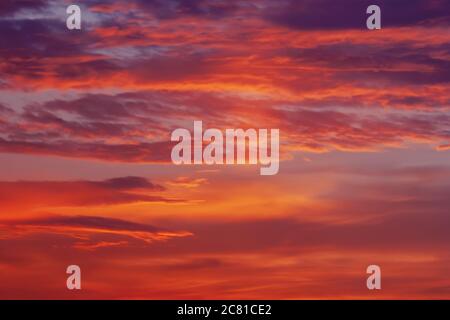 vibrant colorful background of red pink purple orange clouds in sunset sky, blurry dawn sky full frame texture Stock Photo