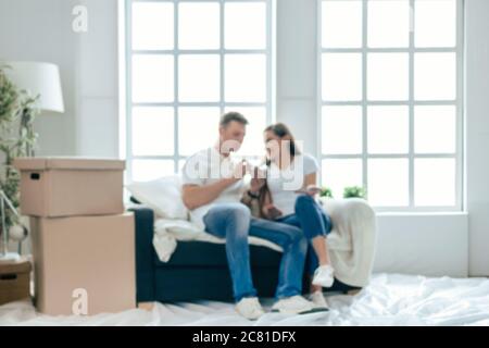 background image of a young couple lying on the floor in an empty new apartment. Stock Photo
