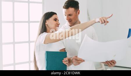 young couple discussing the plan for their new apartment. Stock Photo
