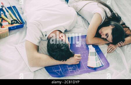 tired young couple is sleeping on the floor in a new apartment. Stock Photo