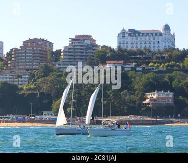 Two yachts sailing past the Hotel Real in the bay of Santander Cantabria Spain on a windy summer day Stock Photo