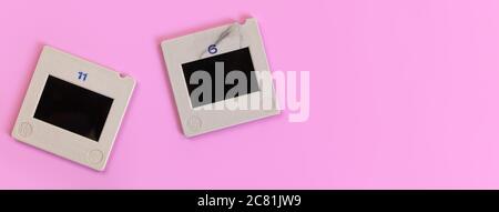 Two diapositive photo slides on pink table, view from above, space for text right side Stock Photo