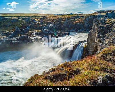Rugged, rocky landscape and flowing cascades from a river; Pingeyjarsveith, Northeastern Region, Iceland Stock Photo
