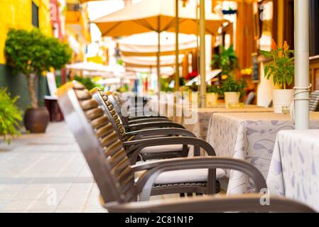 Chairs and tables in an outdoor cafe on a narrow street in Puerto de la Cruz, Tenerife, Spain. Nobody Stock Photo