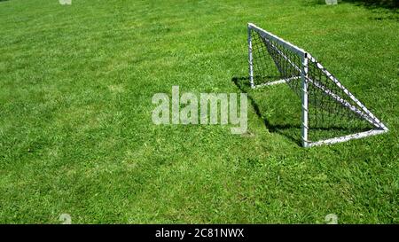 View of freestanding mini soccer goal post net on outdoor football green grass field copy space Stock Photo