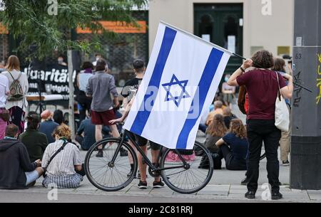 20 July 2020, Saxony-Anhalt, Halle (Saale): A man takes part in a rally with the flag of Israel. The 9 October Halle initiative had called for the event to commemorate the victims of the attack three quarters of a year ago. The trial of 28-year-old terror suspect Stephan B. is scheduled to begin on July 21 in Magdeburg. B. is said to have attempted to enter the well-attended synagogue in Halle on 9 October 2019, heavily armed. When this failed, he is said to have shot two people nearby and injured several people during his escape before he was arrested. Photo: Jan Woitas/dpa-Zentralbild/dpa Stock Photo