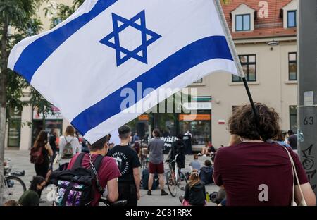 20 July 2020, Saxony-Anhalt, Halle (Saale): A man takes part in a rally with the flag of Israel. The 9 October Halle initiative had called for the event to commemorate the victims of the attack three quarters of a year ago. The trial of 28-year-old terror suspect Stephan B. is scheduled to begin on July 21 in Magdeburg. B. is said to have attempted to enter the well-attended synagogue in Halle on 9 October 2019, heavily armed. When this failed, he is said to have shot two people nearby and injured several people during his escape before he was arrested. Photo: Jan Woitas/dpa-Zentralbild/dpa Stock Photo