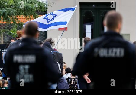 20 July 2020, Saxony-Anhalt, Halle (Saale): Cops are securing a rally. The 9 October Halle initiative had called for the event to commemorate the victims of the attack three quarters of a year ago. The trial of 28-year-old terror suspect Stephan B. is scheduled to begin on July 21 in Magdeburg. B. is said to have attempted to enter the well-attended synagogue in Halle on 9 October 2019, heavily armed. When this failed, he is said to have shot two people nearby and injured several people during his escape before he was arrested. Photo: Jan Woitas/dpa-Zentralbild/dpa Stock Photo