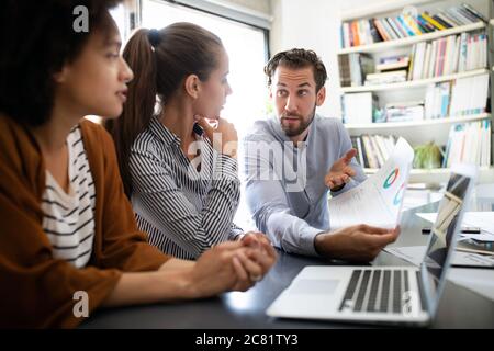 Programmers cooperating at IT company developing apps Stock Photo