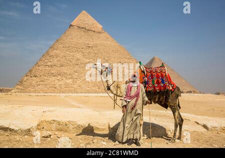 Local man with camel, Pyramid of Khafre, Giza Pyramid Complex, UNESCO World Heritage Site; Giza, Egypt Stock Photo