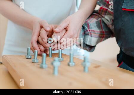 Closeup of man in occupational therapy screwing nut on bolt Stock Photo