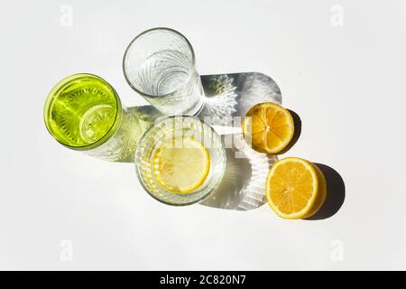 Modern glasses with shadows and lemons. Summer still life scene Stock Photo