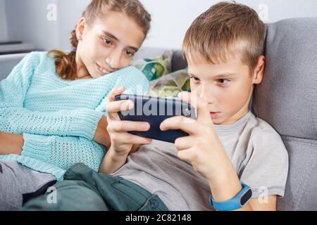 Boy with his sister spending time online at home Stock Photo