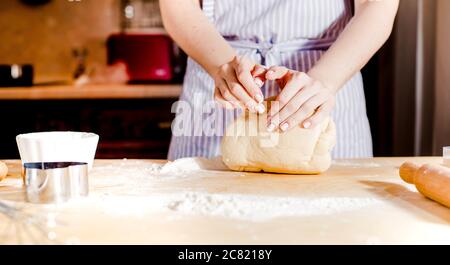 Making dough by female hands on wooden table Stock Photo
