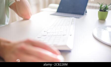 the developer works at the computer, typing, uses the mouse. Selective focus Stock Photo