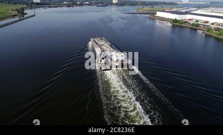 Aerial view of tugboat pushing tanker along the Arthur Kill between New York and New Jersey Stock Photo