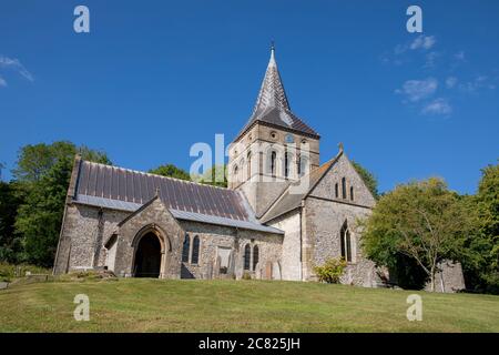 All Saints parish Church in East Meon on a summers day. Impressive flint stone building set against a blue sky. Stock Photo