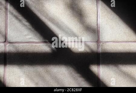 Abstract concept of soft shadows of the sunlight through a window on a tile background Stock Photo