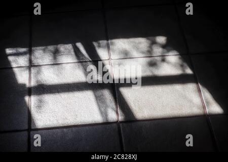 Abstract concept of soft shadows of the sunlight through a window on a tile background Stock Photo