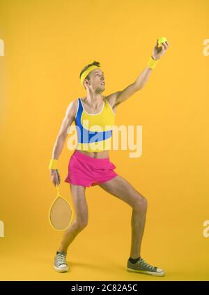 Portrait of a funny tennis player isolated on yellow background. Stock Photo