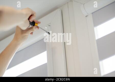 Man installing cassette roller blinds on windows Stock Photo