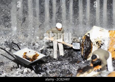 Unique scale model of miniature characters working in cigarette ashes Stock Photo