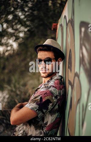 Handsome guy smiling and posing with crossed arms and sunglasses Stock Photo